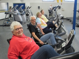 People riding stationary, recumbent bikes